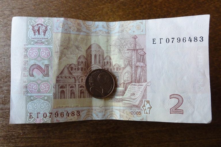 Банкнота 2 гривні і монета на столі