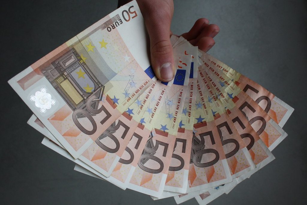 Банкноти євро в руці — купівля валюти може вплинути на житлову субсидію